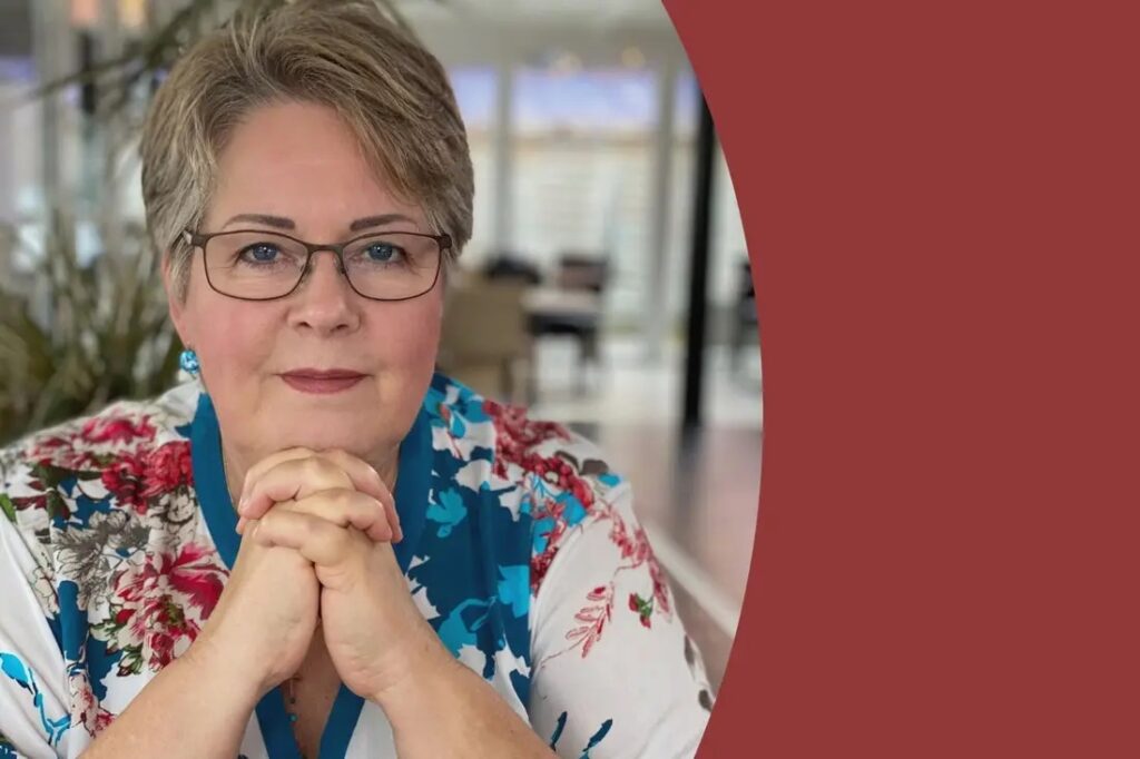Achtsamkeitslehrerin Doris Kirch schaut mit klarem Blick freundlich in die Kamera.